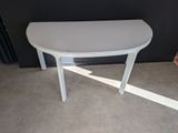 une table blanche au plateau incurvé, dans une pièce