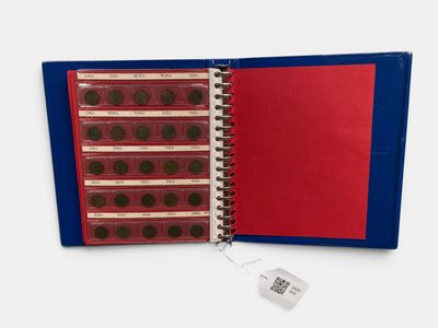 a red and blue binder with coins in it and a tea bag