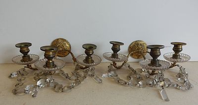 Quatre bougies sont posées sur une table près d'un mur blanc.