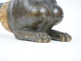a statue of a dog laying down on a white surface