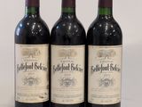 trois bouteilles de vin rouge posées sur une table blanche