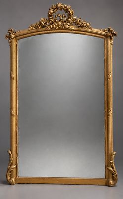 un miroir richement sculpté, avec un cadre doré sur fond gris