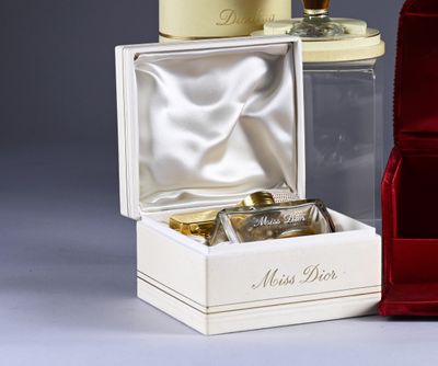 a red box with a bottle of perfume next to it