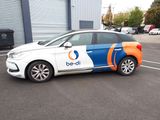 a white car with a blue and orange stripe parked in a parking lot