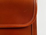brown leather case with white stitching on the inside of it