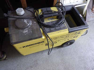 une petite machine jaune à laquelle est raccordé un tuyau