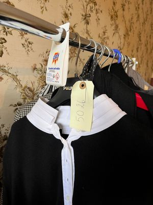 a lot of clothes hanging on a rack in a room