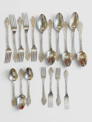 de nombreuses cuillères et fourchettes en argent disposées sur la table