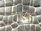 a close up of a metal object with a lizard skin pattern