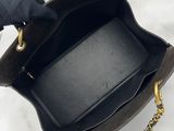 someone is holding a black purse with a gold chain around it