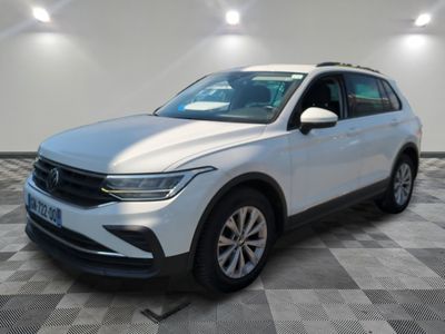 a white volkswagen suv parked in a room with a checkered floor