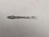 a silver spoon and a fork on a white surface
