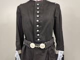 an image of a mannequin wearing a black coat and white gloves