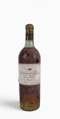 an old bottle of wine sitting on top of a white surface