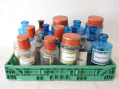 many bottles in a green crate on a white surface