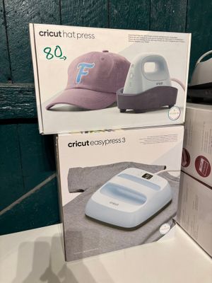 deux boîtes de chapeaux Cricut et une presse à chapeaux posées sur un comptoir