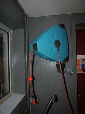 un tuyau bleu fixé au mur d'une salle de bains