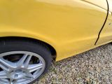 a yellow car that is parked on the side of the road