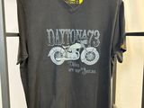 un t-shirt gris suspendu à un portant métallique dans un magasin