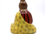 a small figurine of a woman sitting on a rock
