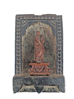 statue d'une femme tenant un enfant dans ses bras, posée sur un socle en pierre