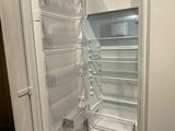 un réfrigérateur blanc dont la porte est ouverte, dans une cuisine