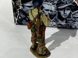 a figurine of a soldier standing in front of a box