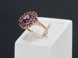 a close up of a gold ring with a purple stone