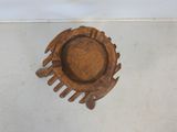 a small wooden plate on the floor next to a white wall