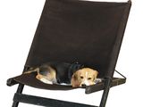 a dog that is laying in a chair on a white background