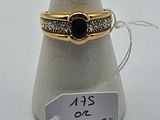 une bague en or surmontée d'une pierre noire