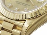 a gold watch with a diamond dial on it