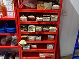 une étagère rouge sur laquelle sont disposés de nombreux objets, dans une pièce