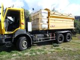 a yellow dump truck that is parked in the grass