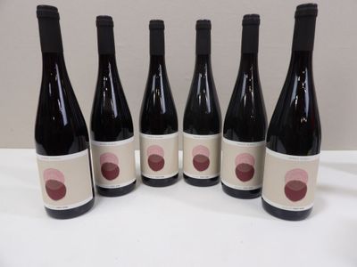 six bottles of wine are lined up on a table