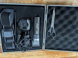 une trousse métallique contenant des ciseaux, des peignes et un sèche-cheveux