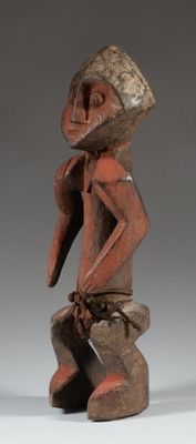 une vieille statue en bois d'un homme avec un chapeau sur la tête
