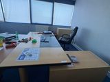 une photo d'un bureau vide avec un bureau et des chaises