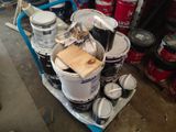 several buckets of paint are stacked on a cart in a garage
