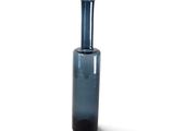 a blue glass vase with a black top on a white surface