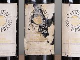three bottles of wine are lined up on a wooden table