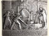 plaque depicting a group of men working in a factory