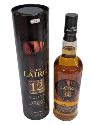 a bottle of whisky sitting next to a black box