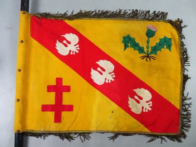 drapeau jaune et rouge orné d'une croix rouge et blanche et de deux crânes