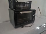 a black microwave sitting on a counter with a basket on top of it