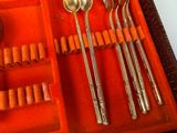 four spoons and two spoons in an orange case