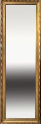 a gold framed mirror sitting on top of a wooden table