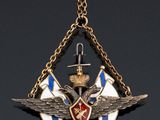 an image of a necklace with a cross and wings on it