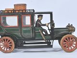 a green toy car with a man sitting in the driver ' s seat