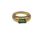 un gros plan d'une bague en or sertie d'une tourmaline verte